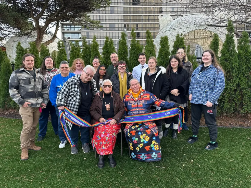 A group of people smiling and posing for a photo in front of a architectural building.